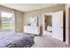 A well-lit bedroom with a white dresser and a view to the adjoining living room and nearby backyard at 8383 Madrid St, Lakeland, FL 33810