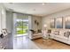 Living room with neutral tones, a plush sofa, stylish decor, and a large window with a backyard view at 8383 Madrid St, Lakeland, FL 33810