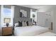Modern bedroom with a gray headboard, accent wall, ensuite bathroom, and large window offering natural light and outdoor views at 8391 Madrid St, Lakeland, FL 33810