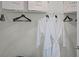 Organized closet with white wire shelving, featuring white robes and hangers, maximizing space and functionality at 8391 Madrid St, Lakeland, FL 33810