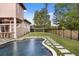 Lush backyard with a sparkling pool, waterfall features, and a well-manicured artificial grass lawn at 9032 Tavolini Ter, Windermere, FL 34786