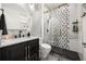 Contemporary bathroom features a sleek vanity, round mirror and glass enclosed shower with black and white tile at 9032 Tavolini Ter, Windermere, FL 34786