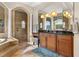 A well appointed bathroom features a vanity with granite countertop, soaking tub, and tiled shower at 9032 Tavolini Ter, Windermere, FL 34786