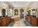 A luxurious bathroom featuring dual vanities, a soaking tub and a separate glass enclosed shower at 9032 Tavolini Ter, Windermere, FL 34786