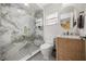 Modern bathroom featuring a marble tiled shower, pebble floor, sleek vanity, and stylish fixtures at 9032 Tavolini Ter, Windermere, FL 34786
