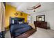 Well-appointed bedroom with a king-sized bed, stylish decor, and a bright yellow accent wall at 9032 Tavolini Ter, Windermere, FL 34786