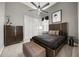 A modern bedroom showcases a dark wooden bed, a ceiling fan, and sleek furnishings at 9032 Tavolini Ter, Windermere, FL 34786