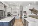 Modern kitchen features white cabinets, marble countertops, stainless steel appliances, and a large island at 9032 Tavolini Ter, Windermere, FL 34786