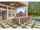 Covered outdoor kitchen with bar seating, stainless steel grill, and view of the beautiful pool at 9032 Tavolini Ter, Windermere, FL 34786