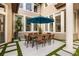 Stylish outdoor patio with a dining table and chairs, surrounded by lush landscaping at 9032 Tavolini Ter, Windermere, FL 34786