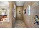 A walk-in shower in neutral tones with arched windows and tile flooring at 9032 Tavolini Ter, Windermere, FL 34786