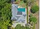 Aerial view of the property featuring a landscaped yard, pool, and lush trees surrounding the home at 996 Fairview Ave, Mount Dora, FL 32757