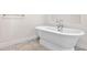 Bright bathroom featuring a standalone bathtub with chrome fixtures and ceramic tile flooring at 996 Fairview Ave, Mount Dora, FL 32757
