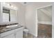 Bathroom featuring white vanity with granite countertop, toilet, and doorway to an attic room at 996 Fairview Ave, Mount Dora, FL 32757