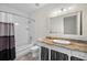 A bathroom featuring a granite-topped vanity and tub with shower at 996 Fairview Ave, Mount Dora, FL 32757