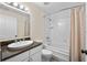Bathroom featuring granite counters, white cabinets and tile surround bathtub at 996 Fairview Ave, Mount Dora, FL 32757