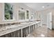 Bright bathroom featuring a double vanity with granite countertop, large windows, and tile flooring at 996 Fairview Ave, Mount Dora, FL 32757