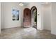 Bright and airy foyer featuring a stone archway entrance, neutral tile floors, and a window for natural light at 996 Fairview Ave, Mount Dora, FL 32757