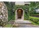 Charming front entrance with stone archway, ivy-covered walls, and lantern lighting at 996 Fairview Ave, Mount Dora, FL 32757