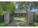 Elegant home entrance with stone pillars, iron gate, and professionally landscaped grounds at 996 Fairview Ave, Mount Dora, FL 32757