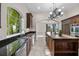A view of the kitchen with stainless steel appliances and black granite countertops at 996 Fairview Ave, Mount Dora, FL 32757