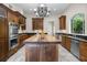 Gourmet kitchen boasts custom wood cabinetry, stainless steel appliances, a large island with sink, and granite countertops at 996 Fairview Ave, Mount Dora, FL 32757