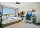 Modern bedroom with a TV, a ceiling fan, blue curtains, and a comfortable workspace at 10940 Leafshore Loop, Orlando, FL 32829