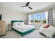 Bright bedroom featuring a large window, ceiling fan, stylish curtains, and an accent beanbag at 10940 Leafshore Loop, Orlando, FL 32829
