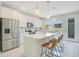 Modern kitchen with white cabinets, stainless steel appliances, an island with breakfast bar, and a view of the back yard at 10940 Leafshore Loop, Orlando, FL 32829