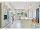 Bright kitchen with white cabinets, stainless steel appliances, an island with seating, and an exterior door at 10940 Leafshore Loop, Orlando, FL 32829