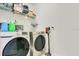 Laundry room with modern washer and dryer and overhead shelf storage at 10940 Leafshore Loop, Orlando, FL 32829