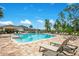 Community pool with lounge chairs on a brick patio, palm trees, and clear blue water at 10940 Leafshore Loop, Orlando, FL 32829