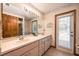 Bathroom featuring double sinks, vanity, and a door leading to the outdoor area at 1130 Woodchuck Ct, Orange City, FL 32763