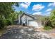 Side exterior featuring a two-car garage, driveway, and home at 1130 Woodchuck Ct, Orange City, FL 32763