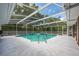 Screened-in pool surrounded by a spacious patio and lush greenery at 1130 Woodchuck Ct, Orange City, FL 32763