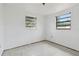 An empty bedroom with a neutral-colored tiled floor, and two windows, with plenty of natural light at 114 Spring Lake Cir, Ocoee, FL 34761