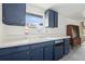 Kitchen with blue cabinets, white countertops, white-tiled backsplash, and a vintage-style cabinet at 114 Spring Lake Cir, Ocoee, FL 34761