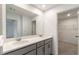 Well-lit bathroom boasts double vanity with white countertop, gray cabinets, and walk-in closet at 11607 Sunsail Ave, Orlando, FL 32832