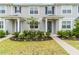 Charming townhome entrance with manicured landscaping and inviting curb appeal and blue door at 11607 Sunsail Ave, Orlando, FL 32832
