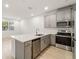 Modern kitchen with gray cabinets, stainless steel appliances, and a center island with a sink at 11607 Sunsail Ave, Orlando, FL 32832