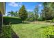 Spacious backyard with a manicured lawn, mature trees, and a secure fence for privacy at 11908 Fiore Dr # 1, Orlando, FL 32827