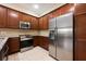 Stylish kitchen boasting stainless steel appliances, granite countertops, and ample dark wood cabinetry for storage at 11908 Fiore Dr # 1, Orlando, FL 32827