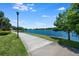 Scenic walking path along a serene lake with clear blue water and lush green surroundings at 11908 Fiore Dr # 1, Orlando, FL 32827