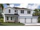 Charming two-story home with light blue siding, stone accents, and a three-car garage at 1339 Wood Line Dr, Deland, FL 32720