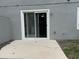 Exterior view of the home featuring a concrete patio and sliding glass door at 135 Heritage Park St, Winter Springs, FL 32708
