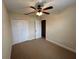 Bedroom with a ceiling fan, neutral walls and carpet, and closet with folding doors at 135 Heritage Park St, Winter Springs, FL 32708