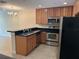 Beautiful kitchen featuring stainless steel appliances, dark countertops, and ample cabinet space at 135 Heritage Park St, Winter Springs, FL 32708