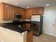Well-equipped kitchen with stainless steel appliances, dark countertops, and ample cabinet space at 135 Heritage Park St, Winter Springs, FL 32708