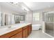 Modern bathroom with double vanity, soaking tub, and glass-enclosed shower at 1545 Caterpillar St, St Cloud, FL 34771