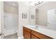 Bright bathroom featuring a white counter, wood vanity, and a large mirror, plus a separate shower and tub area at 1545 Caterpillar St, St Cloud, FL 34771